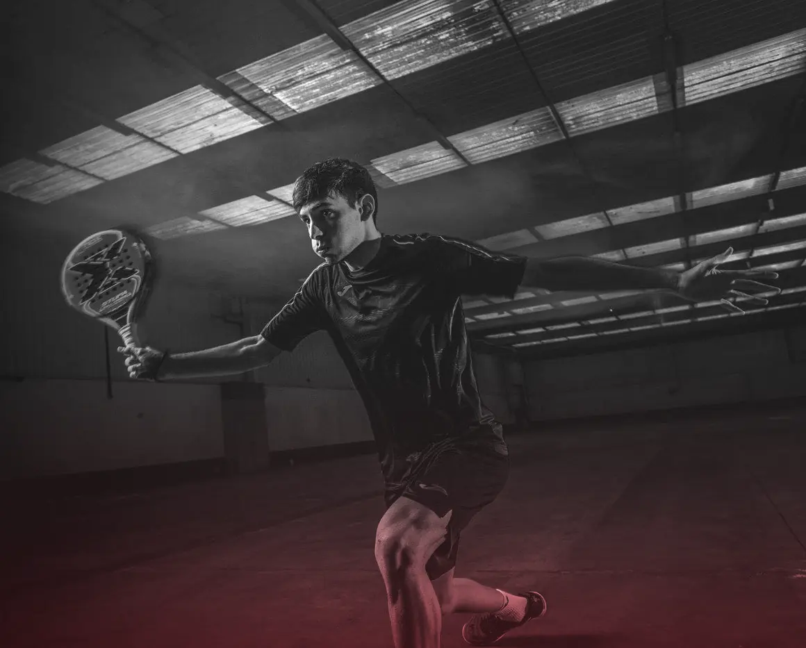 Jugador de pádel en estocada bajo luz roja